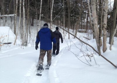 people snowshoeing through the woods