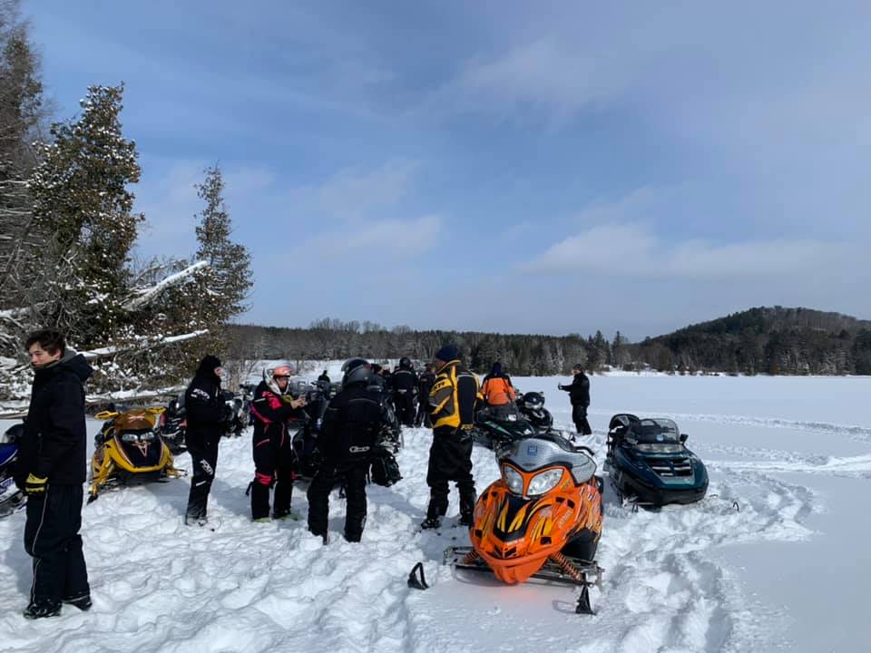 snowmobiles and people on a frozen lake
