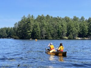 people paddling canoes on a lake